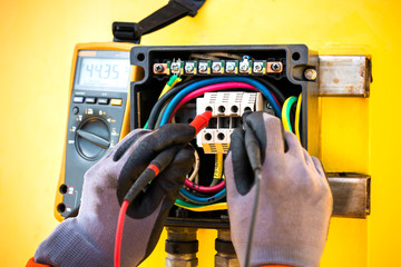 electrician,close up hand of electrician checking voltage by multimeter