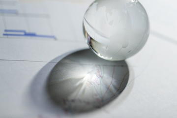 Glass globe on stock market chart