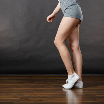 Woman wearing grey shorts, legs only