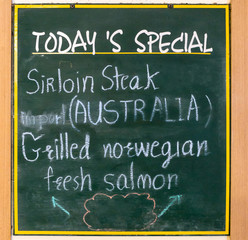 Advertising wooden sign stands in front of restaurant for today's special menu.