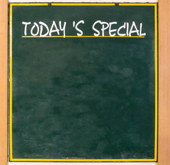 Fototapeta premium Blank advertising wooden chalkboard stands in front of restaurant for today’s special menu.