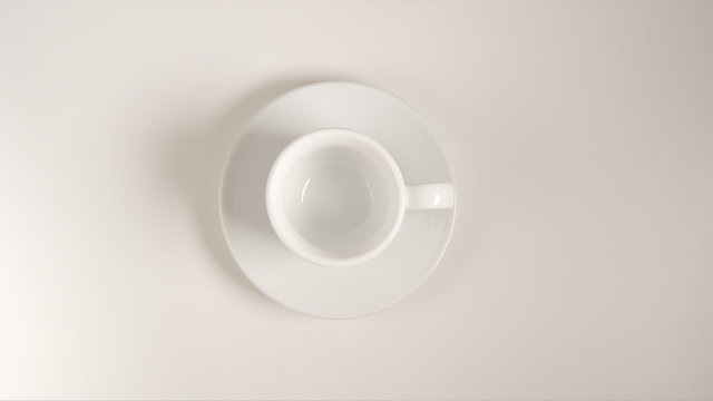 TOP VIEW: White coffee cup on a white table