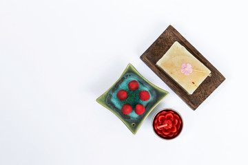 Spa concept on white background, natural soap bar and rose candle with rose incense on green ceramic on white background