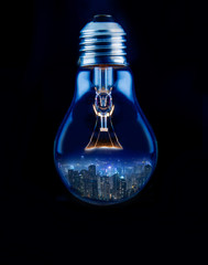 City in a shape of light bulb with dark background.