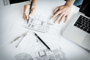 Close-up Of Person's engineer Hand Drawing Plan On Blue Print with architect equipment.