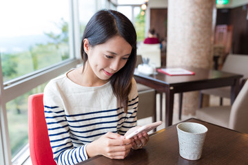 Woman use of mobile phone in coffee shop