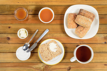 Crispy rolls with butter, apple and hot tea for breakfast