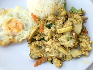 fried seafood with curry powder with rice on white plate with white background.