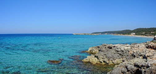 Fototapeta na wymiar Landscape of the beautiful beach of Saint Tomas with a wonderful turquoise sea, Menorca, Spain