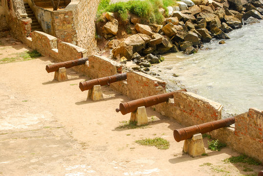 Row of canons aiming out to sea in a fortress