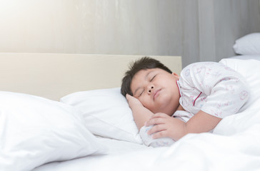 Obraz na płótnie Canvas fat boy sleep on bed