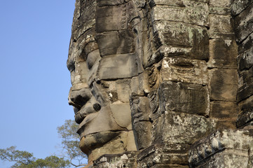 Obraz premium A stone face carved into a tower at the ancient Bayon Temple in Cambodia. Angkor Wat.