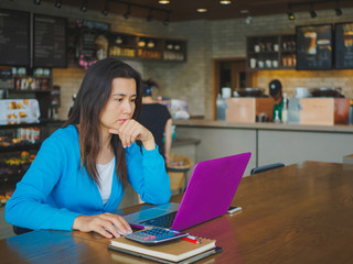 Fototapeta premium Pretty Young womans hands holding and using tablet for online shopping, bill, pencil and calculator on the table. Online payment. Female working on tablet in a cafe.