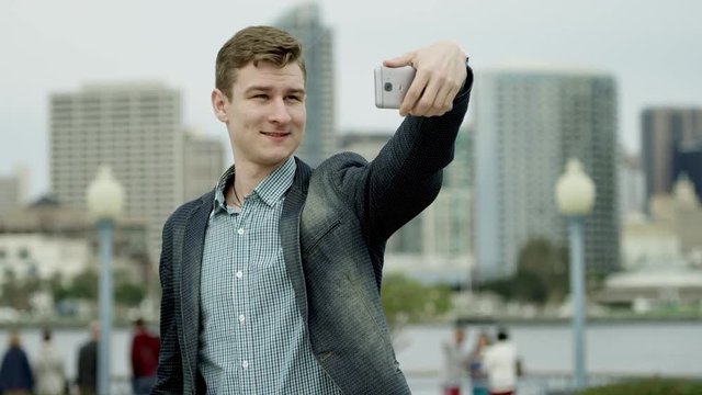 Young man is taking a selfie on a street of Coronado, San Diego