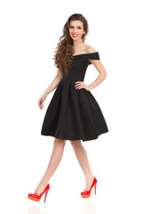 Young Woman In Elegant Black Cocktail Dress Is Walking