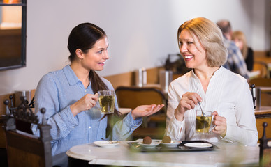 Two female friends at cafe table .