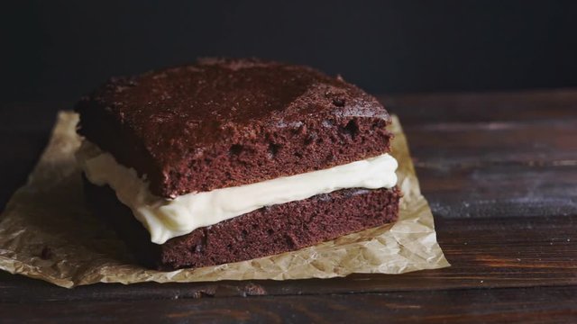 Chocolate icing on cake. Chocolate glaze pouring on homemade dessert. Close up of glaze chocolate cake. Biscuit cake decoration. Topping chocolate dessert