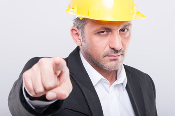 Close-up of foreman wearing hardhat pointing camera