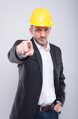 Portrait of foreman wearing hardhat pointing camera