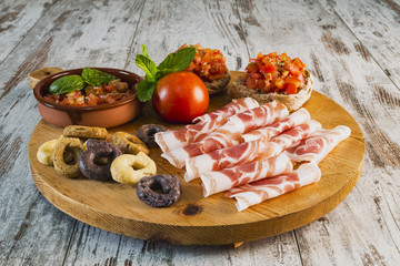 tagliere pancetta friselle pugliesi condite con pomodori e taralli a tre gusti da sopra