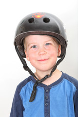smiling blond boy wearing black skate helmet