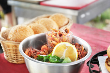 Bowl with shrimps and rolls in wicker basket