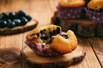 Homemade blueberry muffins on wooden background.