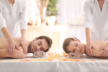 Young happy couple having massage in spa salon