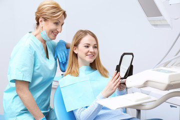 Obraz premium Young woman checking result of dental treatment