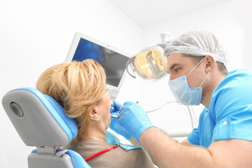 Dentist examining patient's teeth in clinic