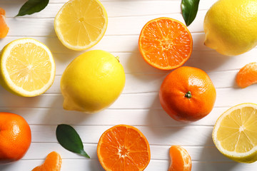 Different citrus fruits on white cutting board, closeup