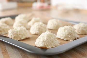 Baking tray with delicious coconut macaroons on table