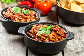Bowls of hot chili con carne with ground beef, beans, tomatoes and corn