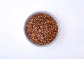 Typical french dijon rough mustard in bowl from isolated on white background