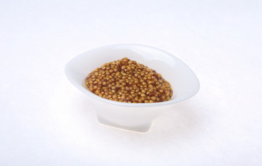 Typical french dijon rough mustard in bowl from isolated on white background