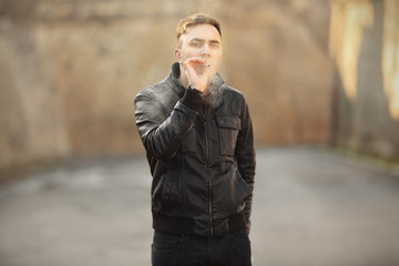 Handsome young man smoking weed outdoors