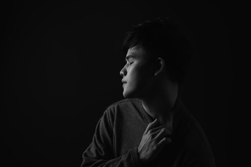 Young asian man's portrait against black background