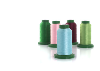 Colored threads on reels on a white background