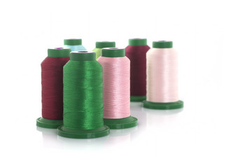 Colored threads on reels on a white background