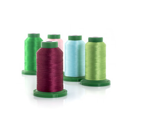 Colored threads on reels on a white background