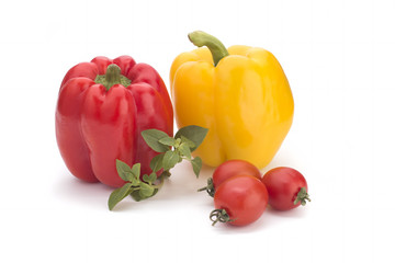 Cherry tomatoes, yellow sweet peppers and a basil branch on a white background