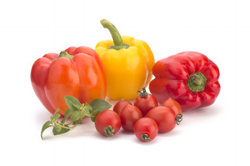 Cherry tomatoes, yellow sweet peppers and a basil branch on a white background