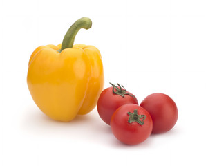 Yellow sweet pepper and red cherry tomatoes on a white background