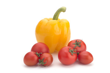 Yellow sweet pepper and red cherry tomatoes on a white background