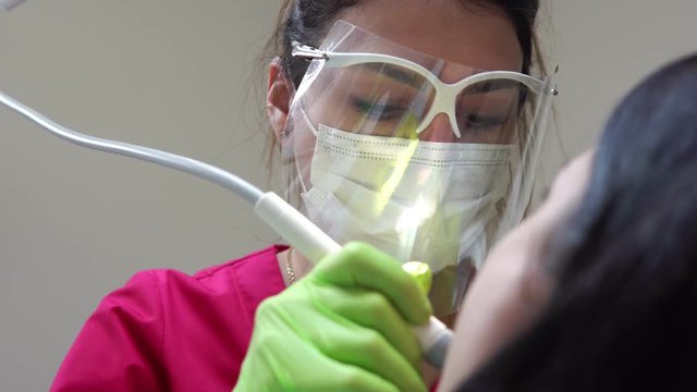 Woman at the dental hygienist getting professional tooth whitening and ultrasound cleaning. Shot in 4k