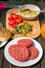 Barbecue, BBQ in the garden. Ingredients. Fresh burger with beef on wooden table.