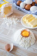 Eggs, flour, butter, pasta or baking ingredients on a wooden table . Selective focus
