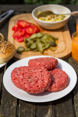 Barbecue, BBQ in the garden. Ingredients. Fresh burger with beef on wooden table.