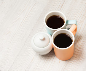Two cups of coffee on white wooden table. Top view, flat lay.