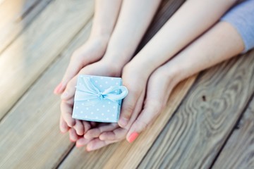 Child and woman holding small gift box